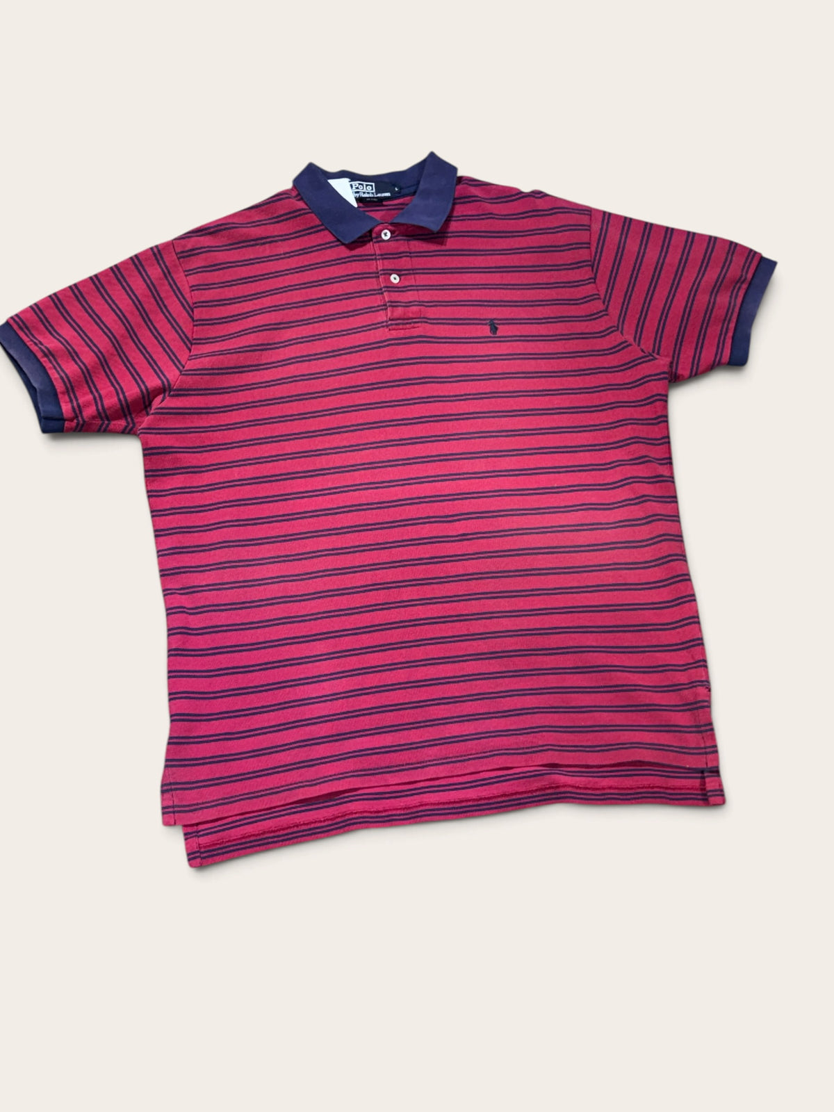 Vue de face du polo Ralph Lauren rayé rouge et bleu marine, à manches courtes et col bleu marine.